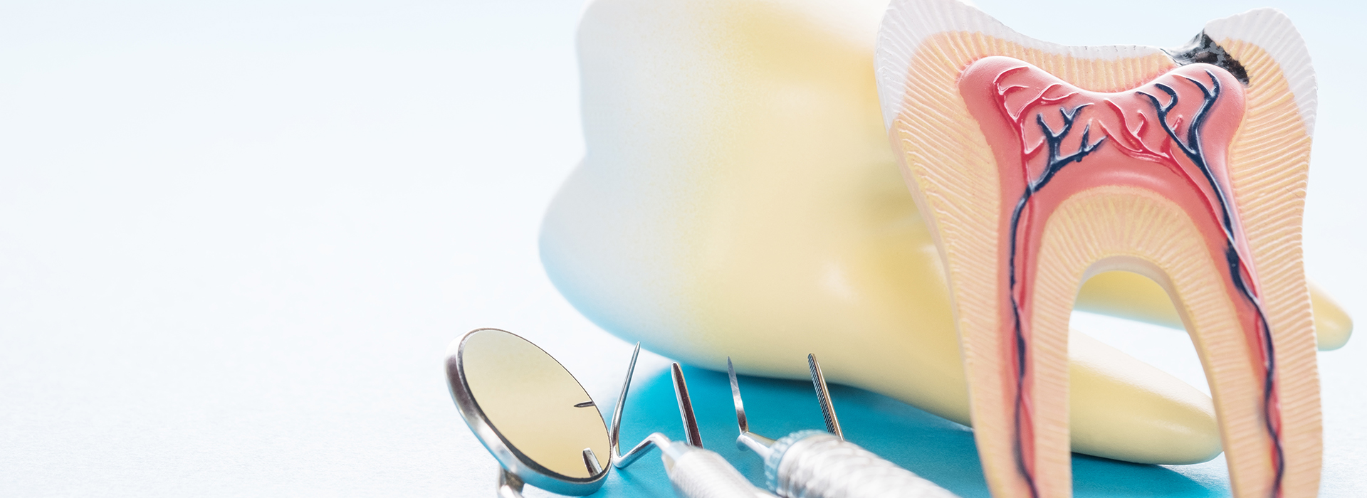 The image shows a close-up of dental tools and an illustration of a tooth with a cavity, placed against a blue background.