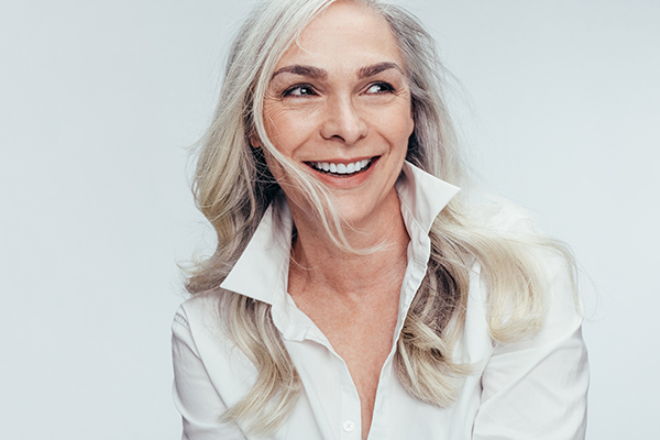 A woman with short hair, smiling and looking directly at the camera.